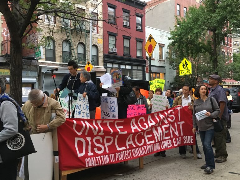 Protesters outside the meeting chanted in English, Spanish and Cantonese.