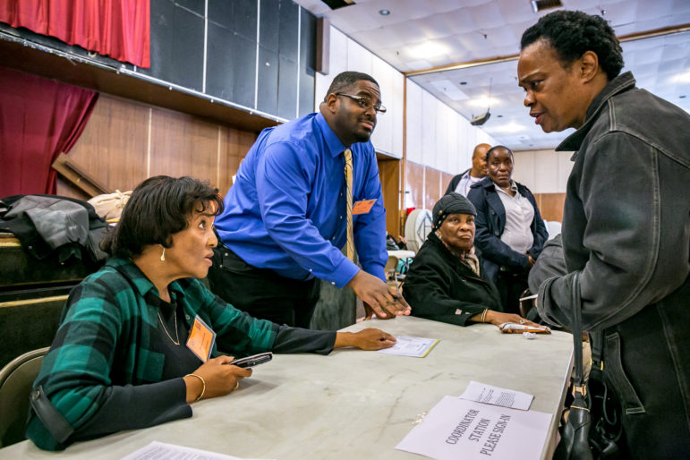 a prospective voter discussing her registration (missing) with election coordinator Ms.Zandra Lolani Coles.