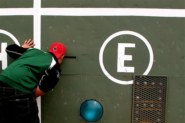 A fan checks out the scoreboard at Fenway Park – site of the World Series game that will follow on the heels of tonight's debate featuring Bill de Blasio's Red Sox. The candidates will almost certainly make grinning reference to the game, though the joke will lose its edge faster than a hanging curveball if tried too often.