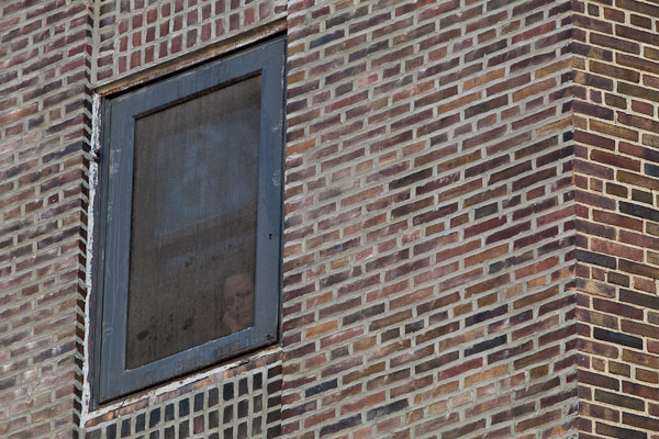 An inmate looks out from Bayview Correctional Facility in Manhattan. In New York's prisons, there is a tension between the rights of inmates -- for whom prison is an involuntary home -- and the rights of guards, whom it is a workplace.