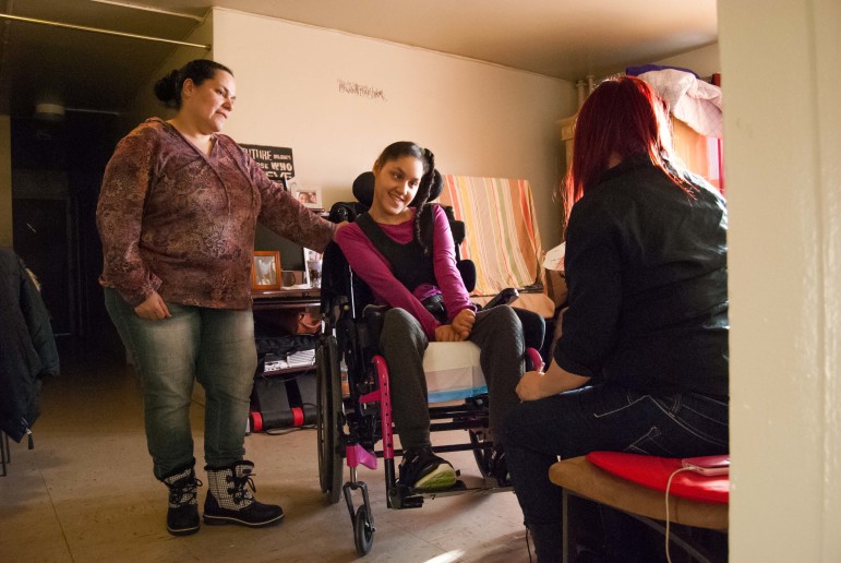 Haydee Perez and her daughter Anna in their Castle Hills apartment with Anna's home aide. They both have asthma and Perez said the mold in their bathroom can make breathing difficult.