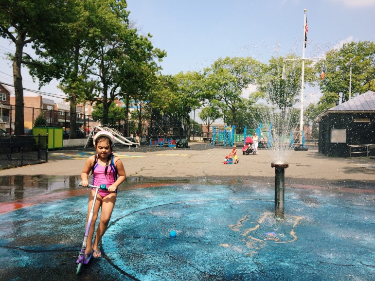 Scooting and splashing through the cooling spray at Loreto Playground.