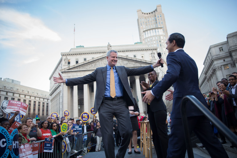 The mayor revs up for a man hug of HUD Secretary  Julián Castro at an affordable housing rally on Wednesday. 