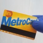 gloved hand holds metrocard