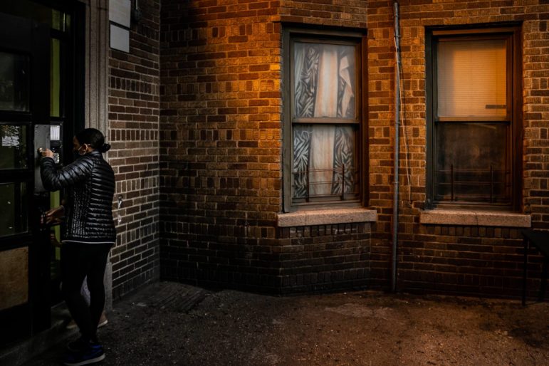 A person opening the door to an apartment building