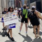 UAW Local 2110 picketers march around Dey Street during a strike against HarperCollins and one supporter raises a sign with the slogan “If Black lives really mattered, they’d pay them a living.”