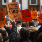 Protest signs against Amazon at a NYC Council hearing in 2019