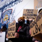 Protestors hold signs calling for the closure of Rikers Island jails