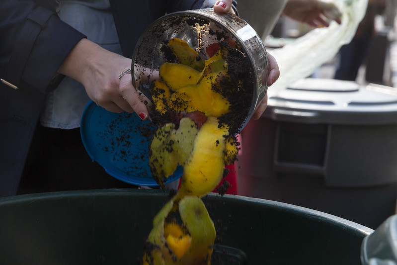 A resident drops off food scraps at a compost collection site in 2021.