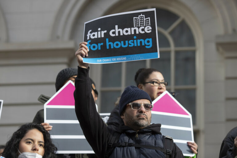 A man holds a sign at a December 2022 rally in support of the Fair Chance for Housing bill.