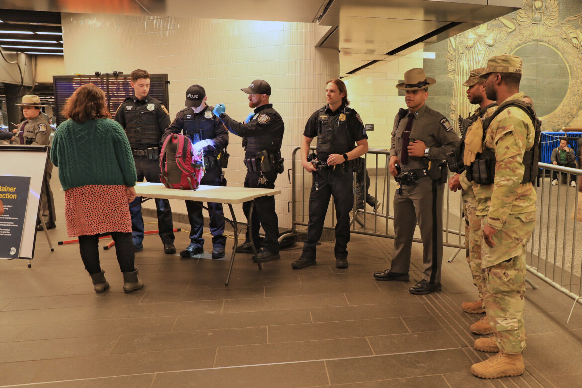 National Guard soldiers perform a back check on the subway