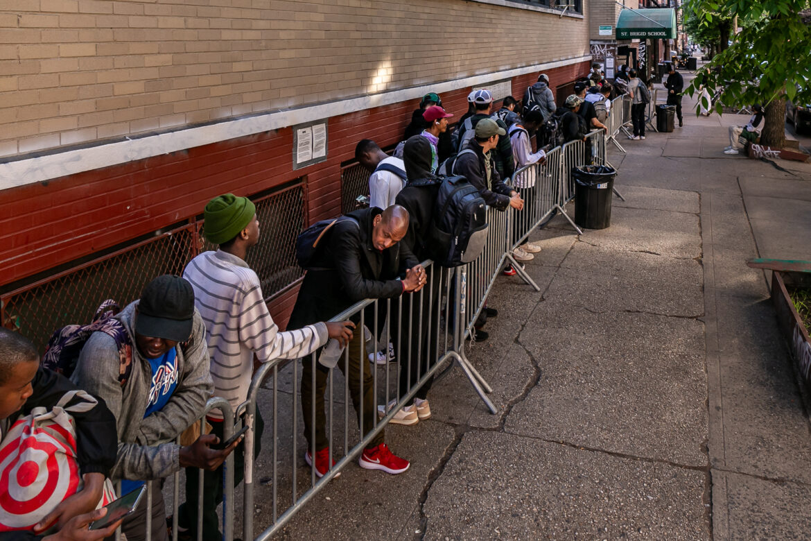 Migrants lined up to reapply for shelter outside St Brigid's School