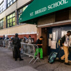 Migrants lined up to reapply for shelter outside St Brigid's School