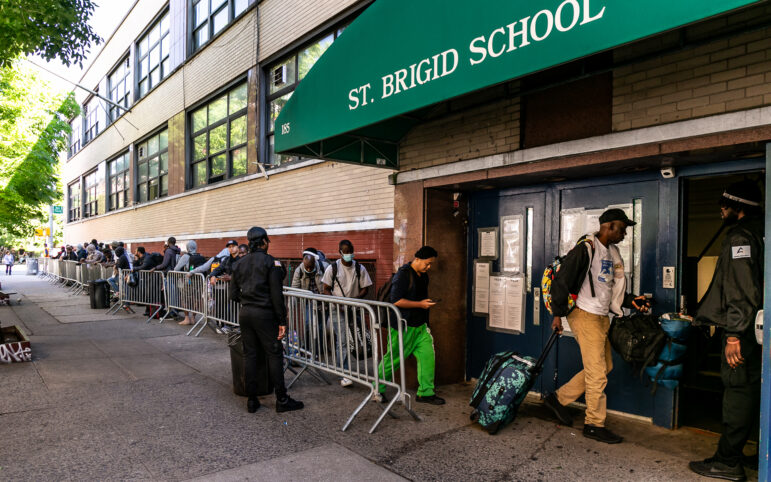 Migrants lined up to reapply for shelter outside St Brigid's School